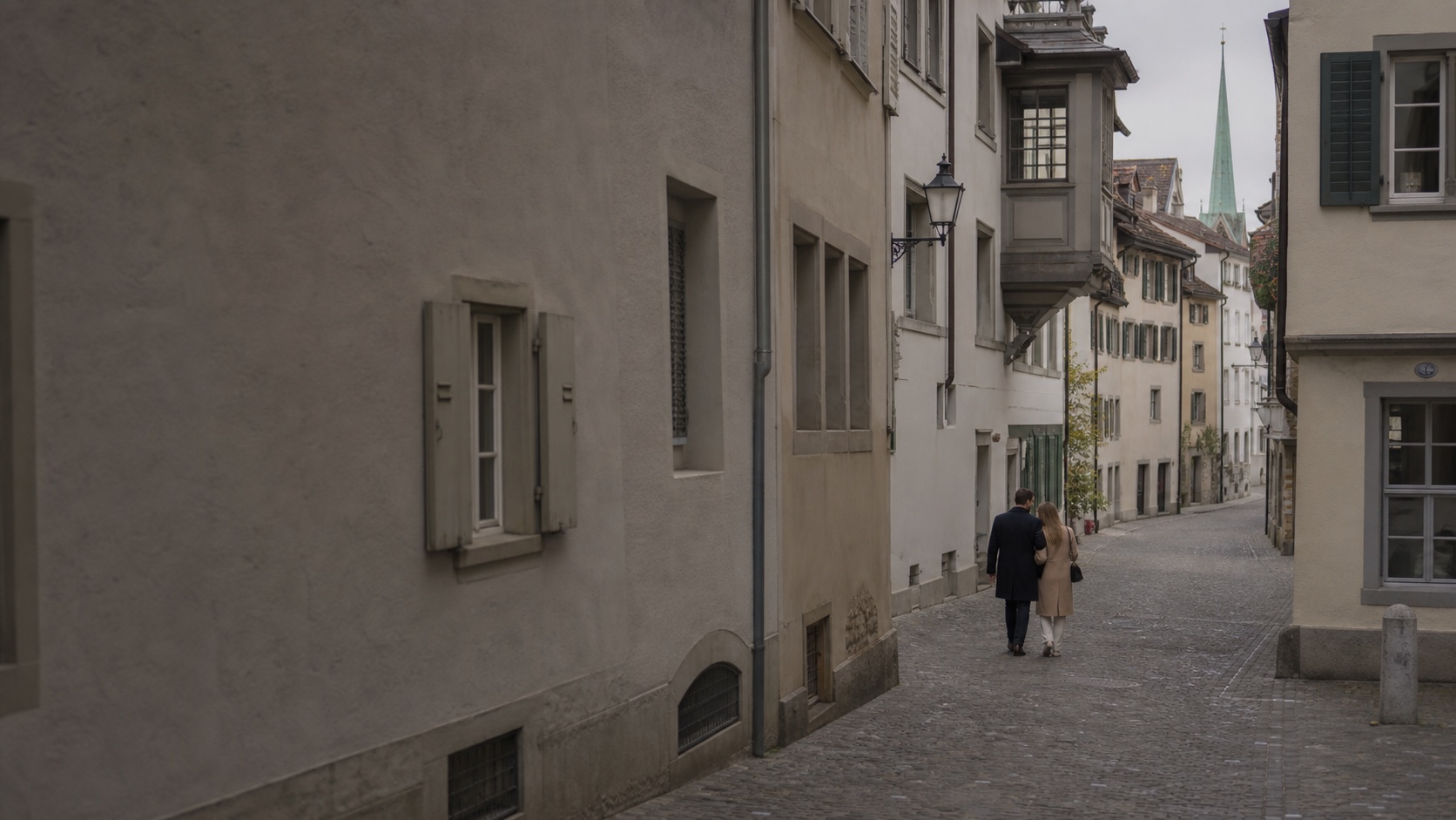 Image illustrative d’un couple vu de dos dans une rue calme de la vieille ville de Zurich.